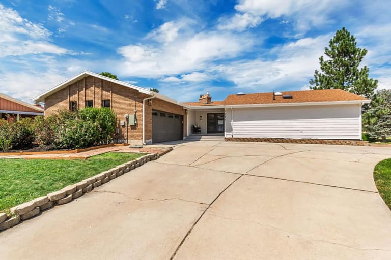 Brick home with white-sided addition wing and attached garage — Utah home addition by CasaMás Construction