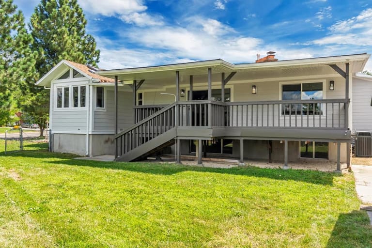 Single-story ranch home with covered back deck above walkout basement — Utah home addition by CasaMás Construction